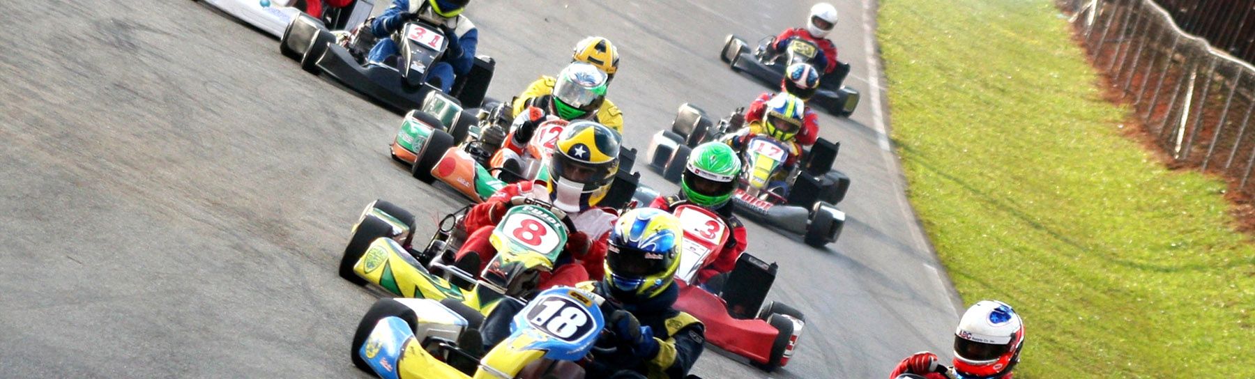 go-karts racing down the track 1800x544